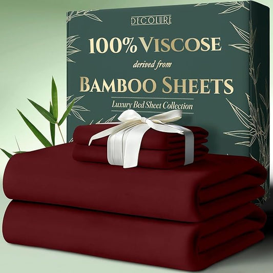 Stacked burgundy bamboo viscose sheets with white ribbon, next to green bamboo-themed packaging box.