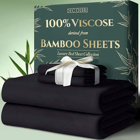 Charcoal bamboo sheet set folded with white ribbon, placed in front of green packaging box with bamboo design.