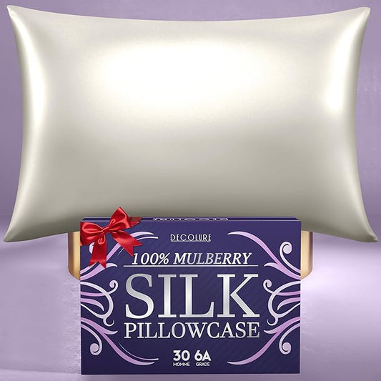 Ivory silk pillowcase with smooth, shiny texture resting above purple packaging box with floral design and red ribbon bow.