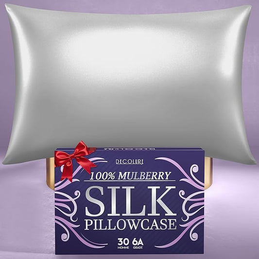 Silver grey silk sleep pillowcase with sheen over a purple background and boxed packaging with red ribbon.