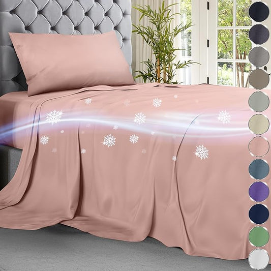Light pink cooling sheet set on tufted gray bed with snowflake graphics and airy blue airflow effect.