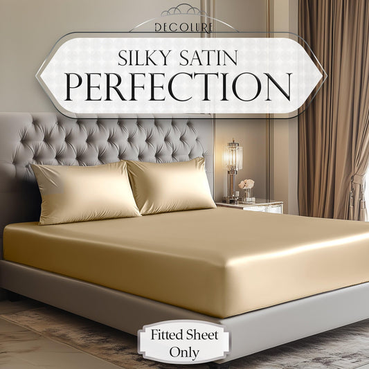 Ivory satin fitted sheet and matching pillowcases on a tufted bed in a neutral-toned bedroom.
