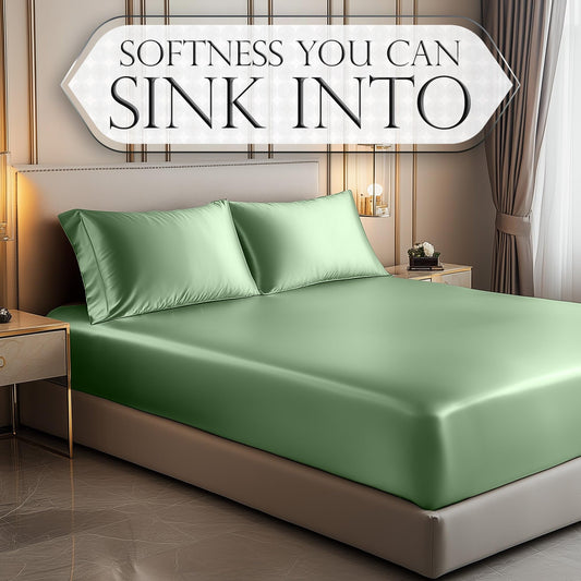 Satin fitted sheet in smooth sage green on bed with matching pillowcases and beige base.