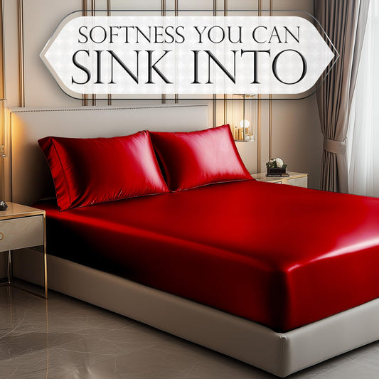 Luxurious red satin fitted sheet with matching pillowcases on modern bed in elegant bedroom.