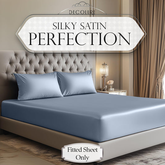 Baby blue satin fitted sheet on a tufted bed with matching pillowcases in a neutral-toned bedroom.