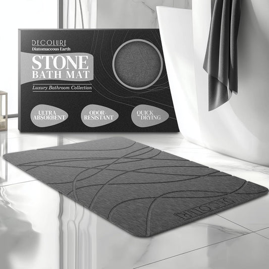 Gray stone bath mat with modern design, placed on glossy bathroom floor near curtain and packaging box