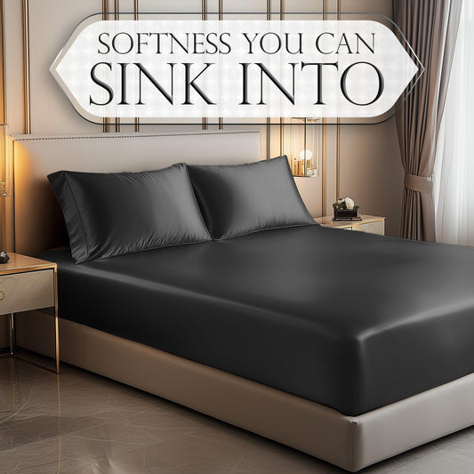 Stone grey satin fitted sheet with matching pillowcases on bed in elegant bedroom.