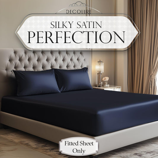 Navy blue satin fitted sheet on bed with matching pillowcases in modern bedroom.