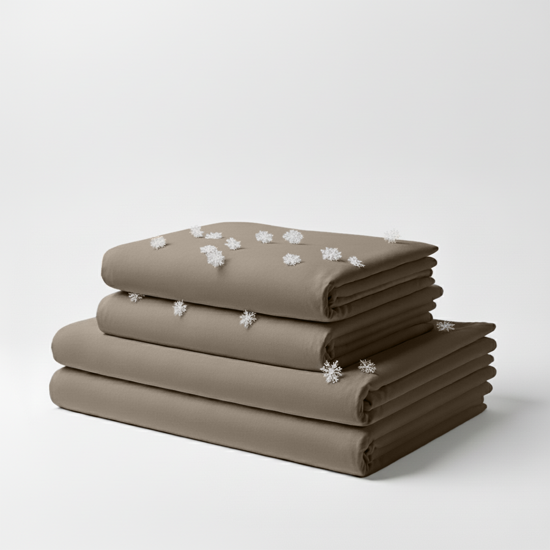 Neatly folded beige cooling sheet set with subtle texture on white background.