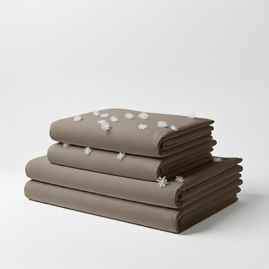 Neatly folded beige cooling sheet set with subtle texture on white background.