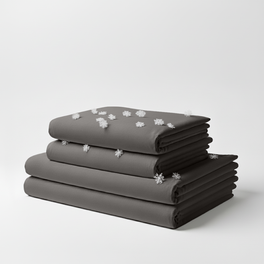 Stacked cool grey folded cooling sheet set with small white snowflake icons scattered on top.