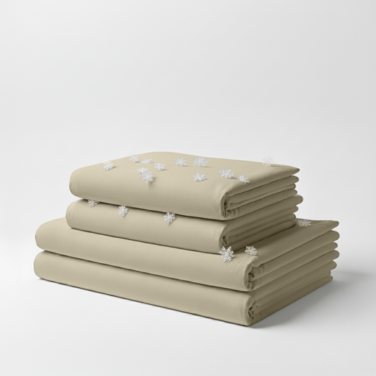Folded cream-colored cooling sheet set with a smooth, soft texture against a plain background.
