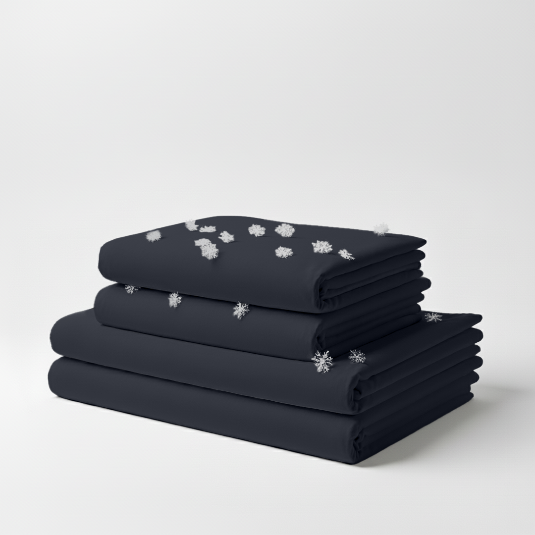 Stack of neatly folded midnight black cooling bed sheets with snowflake icons indicating cooling effect.