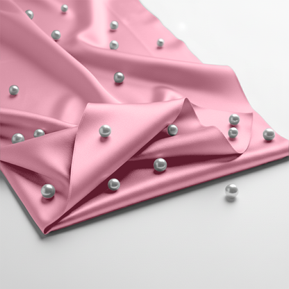 Soft pink satin fitted sheet with smooth, shiny texture and scattered silver beads.