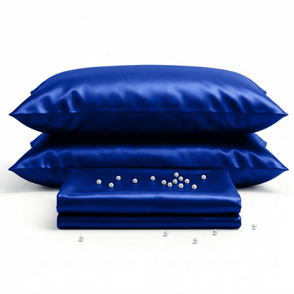 Set of blue satin pillows and a folded sheet on a white background