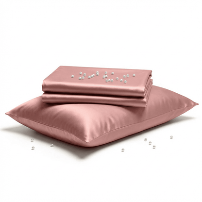 Pink satin sheet set with pillowcase on a white background