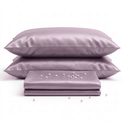 Set of satin pillows and a sheet with pearls on a white background