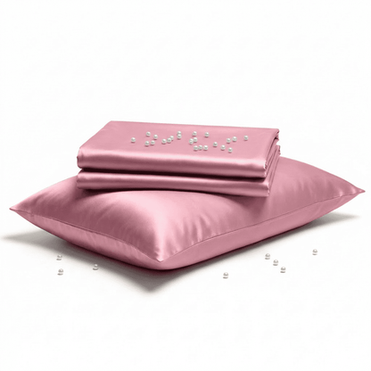 Pink satin sheet set with pillowcase on a white background