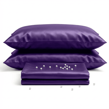 Purple satin pillowcases and a sheet on a white background