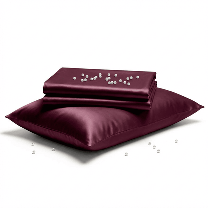 Burgundy satin pillowcase and matching pillow on a white background