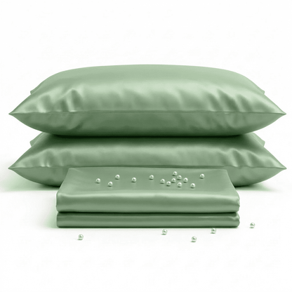 Set of green satin pillows and a matching sheet on a white background