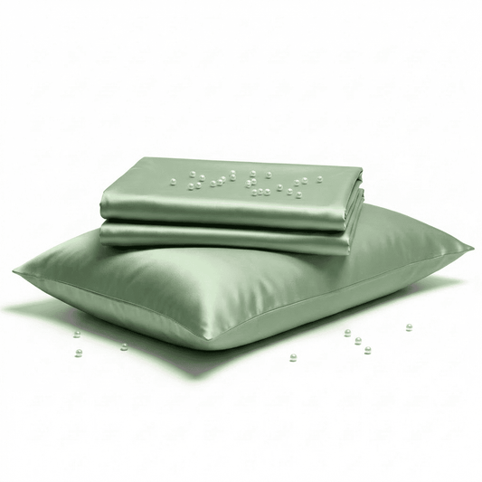 Set of green satin sheets and pillowcases on a white background