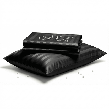 Black satin pillow and blanket set on a white background