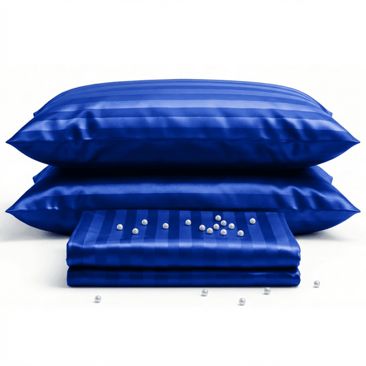 Blue satin pillowcases and a matching quilt on a white background