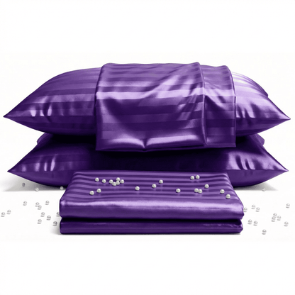 Purple satin pillows and a sheet with pearls on a white background