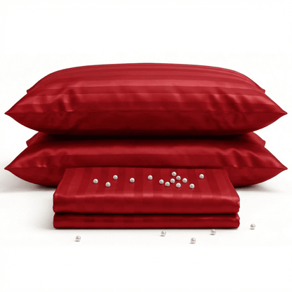 Red satin pillowcases and a folded red satin sheet on a white background