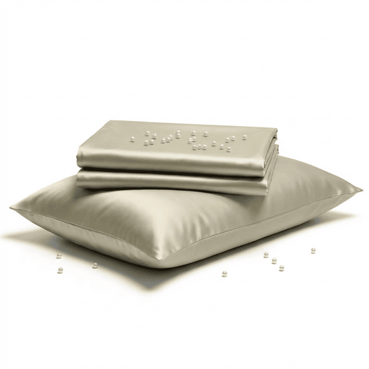 Set of light gray bedding including a fitted sheet, flat sheet, and pillow on a white background.