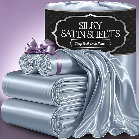 Baby blue silky satin sheets with smooth, glossy finish, neatly folded and rolled with a purple ribbon on a purple background.