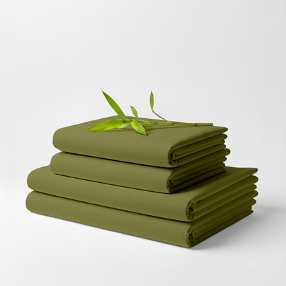 Light olive bamboo sheet set folded with a small green bamboo sprig on top.