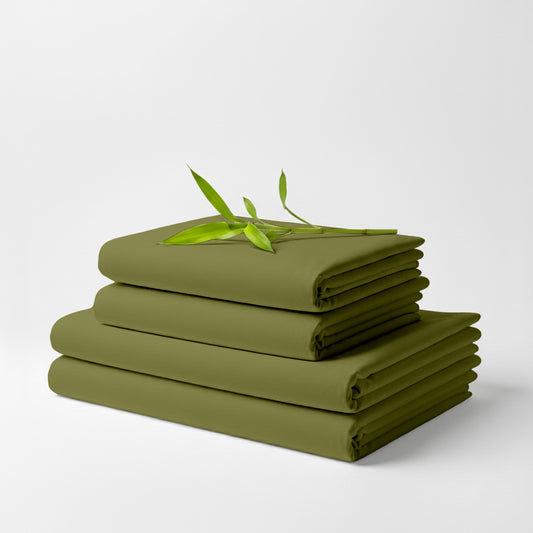 Light olive bamboo sheet set folded with a small green bamboo sprig on top.