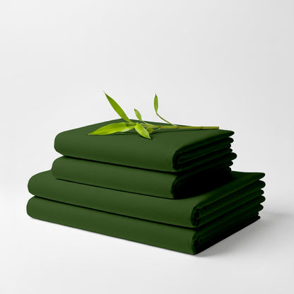 Stack of neatly folded olive green bamboo bed sheets with a small green leafy branch on top.