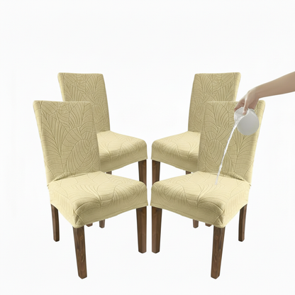 Set of four beige waterproof dining chair covers with textured leaf pattern and water being poured on one cover.