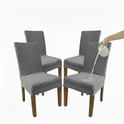 Set of four gray dining chairs with a person using a spray bottle on one chair.