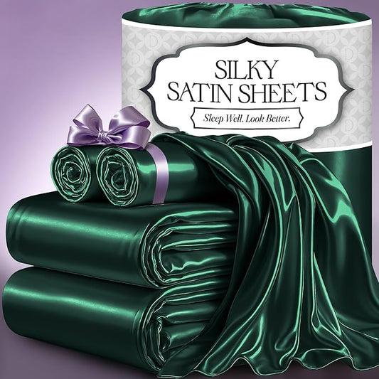 Dark green silky satin sheet set with smooth, glossy finish and matching pillowcases tied with lavender ribbon.