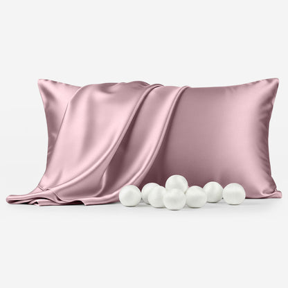 Coral silk pillowcase with smooth, shiny texture and six white decorative balls in front.