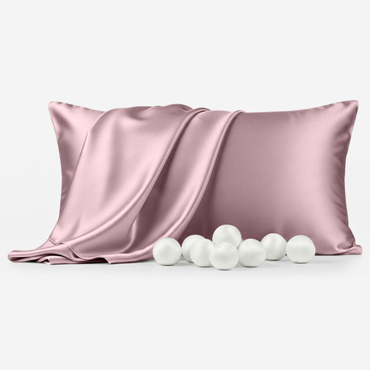 Coral silk pillowcase with smooth, shiny texture and six white decorative balls in front.