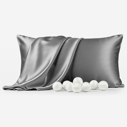 Grey silk pillowcase with smooth, shiny texture next to scattered white balls.